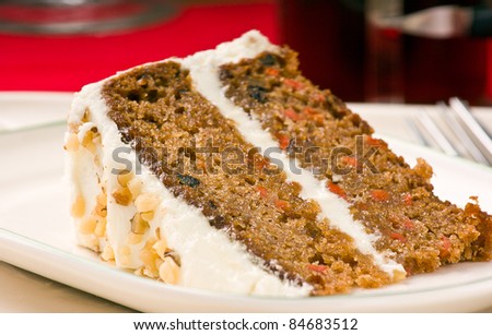 Sweet slice of walnut carrot cake on white plate. Shallow depth of field.