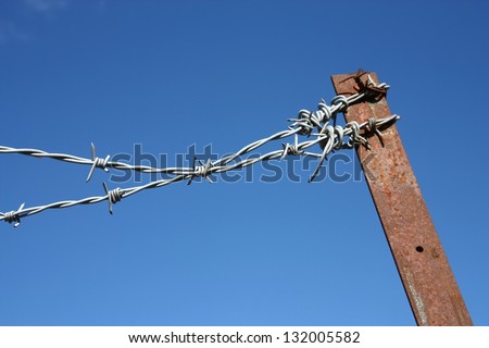 Industrial area fence - metal barbed wire. Property security.