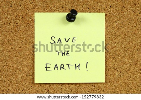 Yellow sticky note pinned to an office notice board. Save the earth - environmental message, ecology concept.