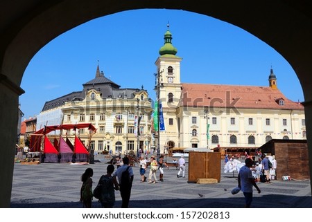 SIBIU, ROMANIA - AUGUST 24: Tourists visit main square on August 24, 2012 in Sibiu, Romania. Sibiu\'s tourism is growing with 284,513 museum visitors in 2001 and 879,486 visitors in 2009.