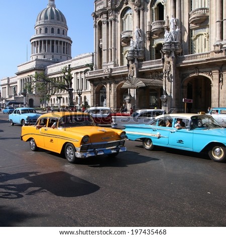 HAVANA, CUBA - FEBRUARY 27, 2011: People drive Classic American cars in Havana, Cuba. Cuba has one of the lowest car-per-capita rates (38 per 1000 people in 2008).