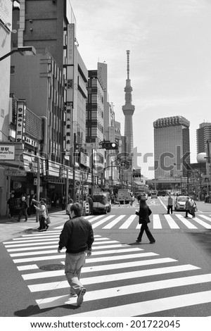 TOKYO, JAPAN - APRIL 13, 2012: Man crosses street in Asakusa district, Tokyo. Asakusa is one of the oldest districts of Tokyo, largest urban area of Japan (35 million people in metro area).
