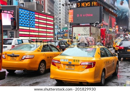 NEW YORK, USA - JUNE 10, 2013: Taxis drive at Times Square in New York. Times Square is one of most recognized landmarks in the world. More than 300,000 people pass through Times Square daily.