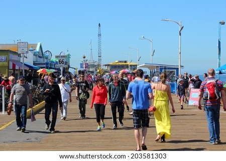 SANTA MONICA, UNITED STATES - APRIL 6, 2014: People visit the pier in Santa Monica, California. As of 2012 more than 7 million visitors from outside of LA county visited Santa Monica annually.