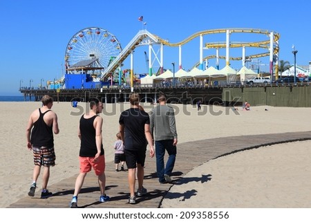 SANTA MONICA, UNITED STATES - APRIL 6, 2014: People visit beach in Santa Monica, California. As of 2012 more than 7 million visitors from outside of LA county visited Santa Monica annually.