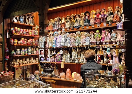 KRAKOW, POLAND - MAY 12, 2014: Vendor sells Polish traditional handicraft souvenirs in Cloth Hall, Krakow. Sukiennice Cloth Hall is part of UNESCO World Heritage Site since 1978.
