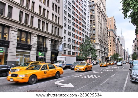 NEW YORK, USA - JULY 3, 2013: People ride yellow taxi in 5th Avenue, Midtown Manhattan in New York. As of 2012 there were 13,237 yellow taxi cabs registered in New York City.