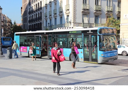 MADRID, SPAIN - OCTOBER 22, 2012: People exit city bus in Madrid. EMT is Madrid\'s main bus operator. It uses fleet of more than 2000 buses and serves about 450 million rides annually (2011).
