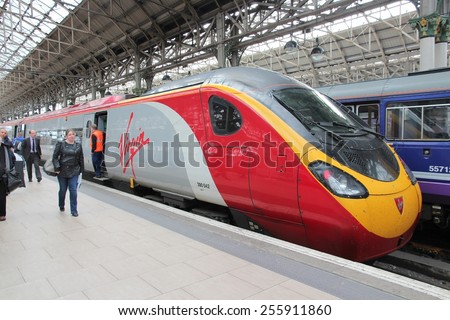 MANCHESTER, UK - APRIL 23, 2013: People exit Virgin Trains Pendolino train in Manchester, UK. Virgin Trains operates since 1997 and as of 2013 uses 56 Class 390 Pendolino train sets.
