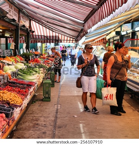 VIENNA, AUSTRIA - SEPTEMBER 6, 2011: Shoppers visit Naschmarkt in Vienna. One of oldest markets in Europe (est. 16th century), it is remarkably large (1.5km long) and popular with tourists.