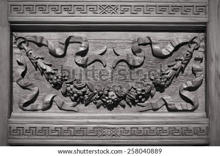 Architecture detail in Madrid, Spain. Wooden door carved decoration. Black and white tone.