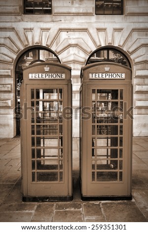 London, England - typical telephone booths. Sepia tone - filtered vintage photo style.