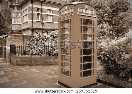 London, England - typical telephone booth. Sepia tone - filtered vintage photo style.