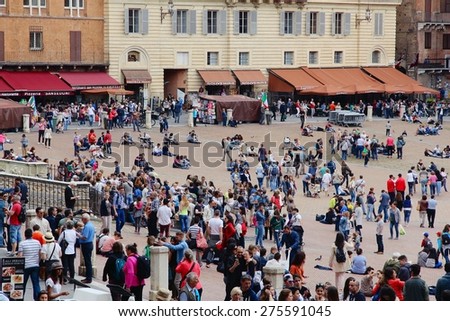 SIENA, ITALY - MAY 3, 2015: People visit Piazza del Campo in Siena, Italy. Siena as a UNESCO World Heritage Site is an important tourism destination in Italy.