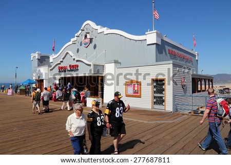 SANTA MONICA, UNITED STATES - APRIL 6, 2014: People visit the pier in Santa Monica, California. As of 2012 more than 7 million visitors from outside of LA county visited Santa Monica annually.