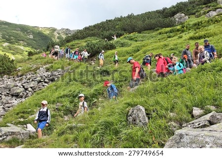 TATRA MOUNTAINS, POLAND - AUGUST 9, 2014: Tourists hike in Tatra Mountains, Poland. Tatra National Park was visited by 2.7 million people in 2013.