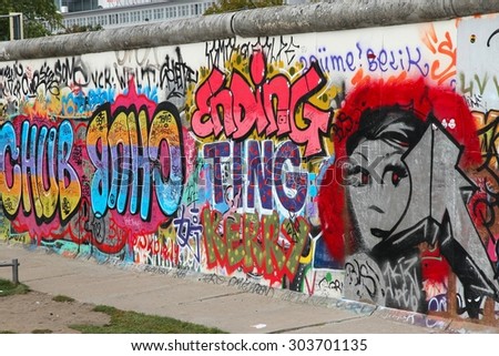 BERLIN, GERMANY - AUGUST 26, 2014: Free public urban art of East Side Gallery at public street in Berlin. Part of former Berlin Wall is covered in art by more than 100 artists since 1990.