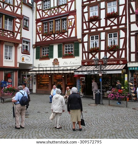 BERNKASTEL, GERMANY - JULY 19, 2011: Tourists stroll in Bernkastel-Kues, Germany. According to its Tourism Office, the town is annually visited by 1.5m tourists. The region is famous for its wines.