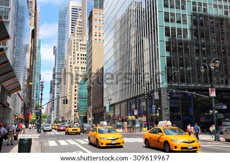 NEW YORK, USA - JULY 4, 2013: People ride yellow taxi cabs along 42nd Street in New York. As of 2012 there were 13,237 yellow taxi cabs registered in New York City.