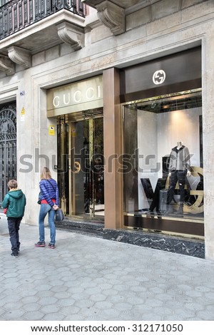 BARCELONA, SPAIN - NOVEMBER 6, 2012: People walk by Gucci fashion shop in Barcelona, Spain. The fashion company founded in 1921 is among most recognized luxury brands in the world.