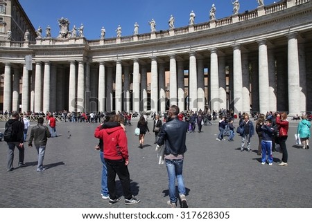 VATICAN CITY, VATICAN - APRIL 9, 2012: People visit Saint Peter\'s Square in Vatican City, Vatican. Saint Peter\'s Square is among most popular pilgrimage sites for Roman Catholics.
