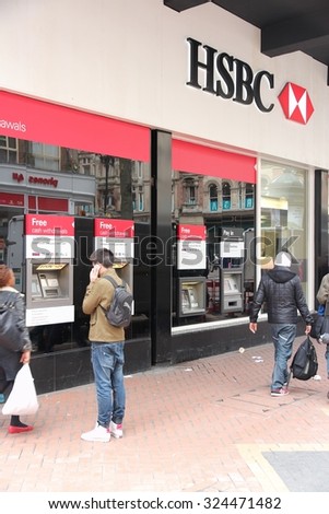 BIRMINGHAM, UK - APRIL 19, 2013: People walk by HSBC Bank in Birmingham, UK. HSBC is one of largest bank groups, holding assets of $2.69 trillion worldwide (2012).