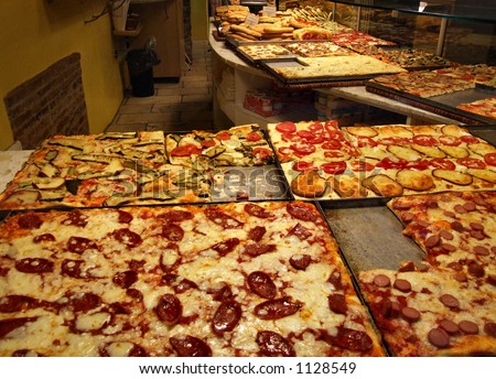 Interior of an Italian pizzeria - kitchen room with many delicious pizzas with different ingredients. Safe, clean and professional. Bon appetit!
