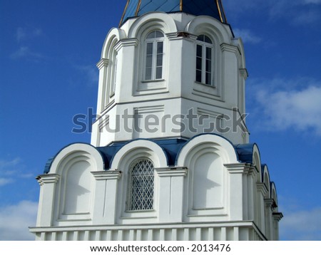 White church tower with blue roofs. Beautiful sunny weather.