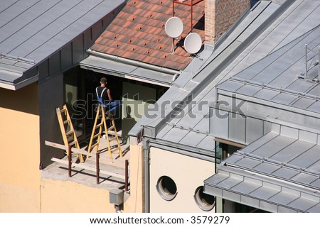 House renovation worker sitting on a ladder. Dangerous job.