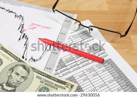 Stock market candle charts, US dollars, remarks with a red marker and glasses