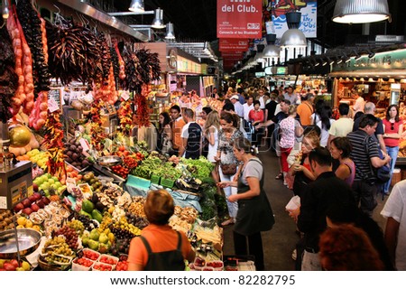 BARCELONA, SPAIN - SEPTEMBER 13: Tourists in famous La Boqueria market on September 13, 2009 in Barcelona. One of the oldest markets in Europe that still exist. Established 1217.
