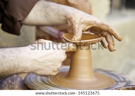 Potter working with clay, detail of a craftsman working in the city