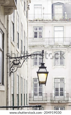 Old street lamp on a classical facade in Lisbon, detail of an old lighting in the city, Art and Tourism