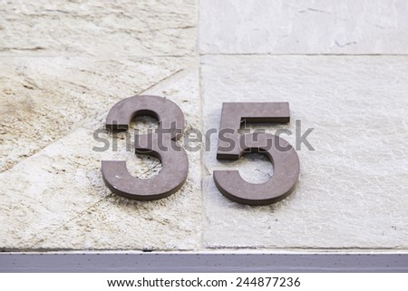 Number thirty-five in a wall, detail of a number of information, odd number