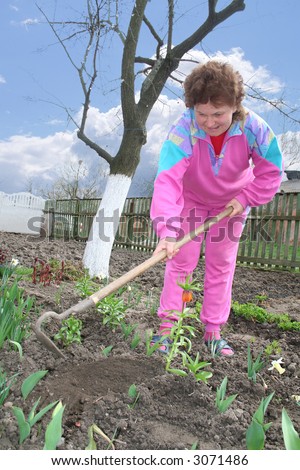 The woman plants flowers in a kitchen garden