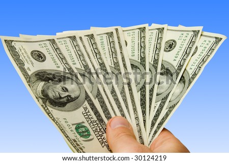 Money in hand over blue vackground (contains clipping path)