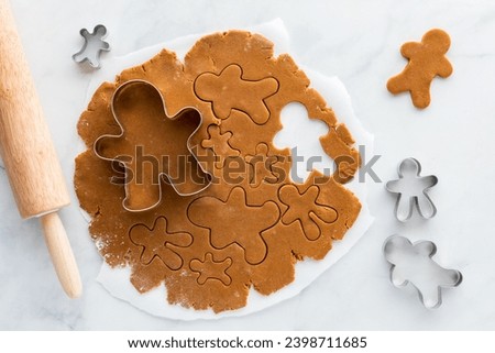 Similar – Image, Stock Photo Gingerbread cookies dough cut in different shapes on a blue table. Baking Christmas cookies