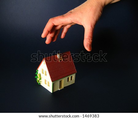 hand reaching for small house