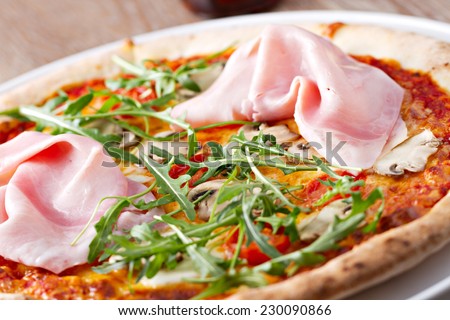 Pizza with ham and roket salad