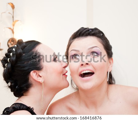 Young woman tells her friend a big secret