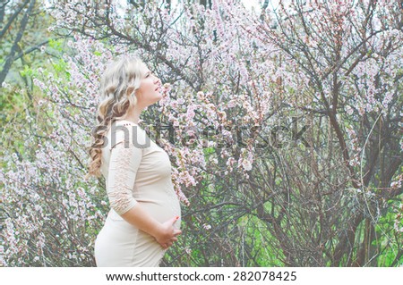 Pregnant Woman embracing her baby bump with hands