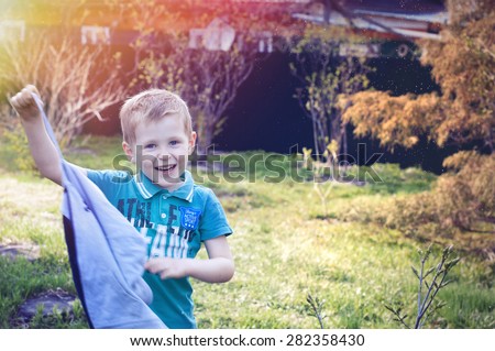 4 years old kid standing and laughing out loud outside in the warm sunny summer day