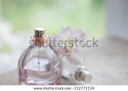 Perfume bottle, floral water with spray and blossom on blurry daylight  background