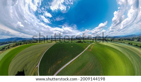 Abstract panoramic aerial view in a forest and field with fantastic beautiful clouds and curvature of space like a small planet Foto d'archivio © 