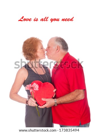 Love is all you need - an elderly couple embracing after the husband gave the wife flowers and chocolates