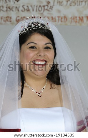 Beautiful smiling Hispanic Bride in veil and tiara before wedding