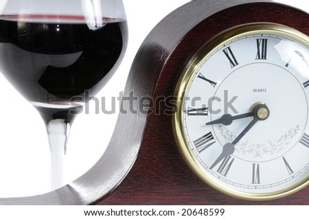 Glass of wine and mantle clock isolated