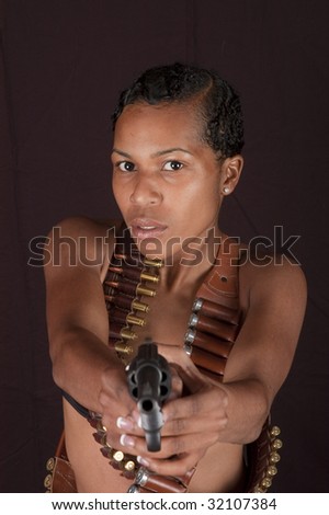 Beautiful  African-American woman isolated on black pointing gun at viewer