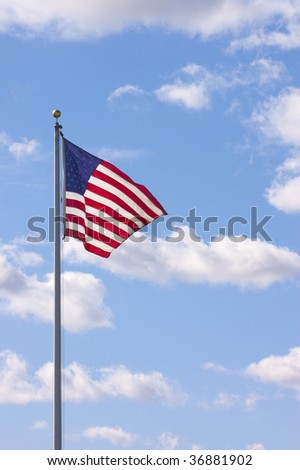 US flag waving with clouds in the sky