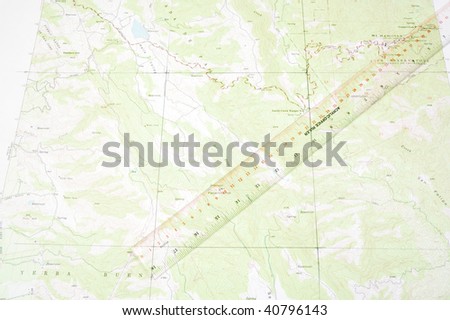 ruler laying on a topographical map to do distance measurement with